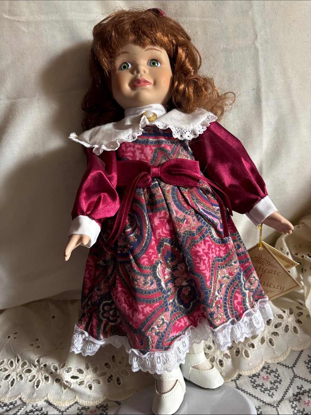 Vintage Porcelain Doll in Burgundy Pink Paisley Dress with stand.